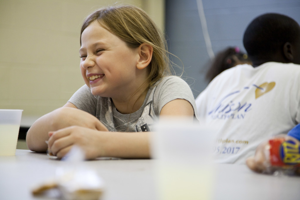 Corporate Photo, girl sitting at table smiling.